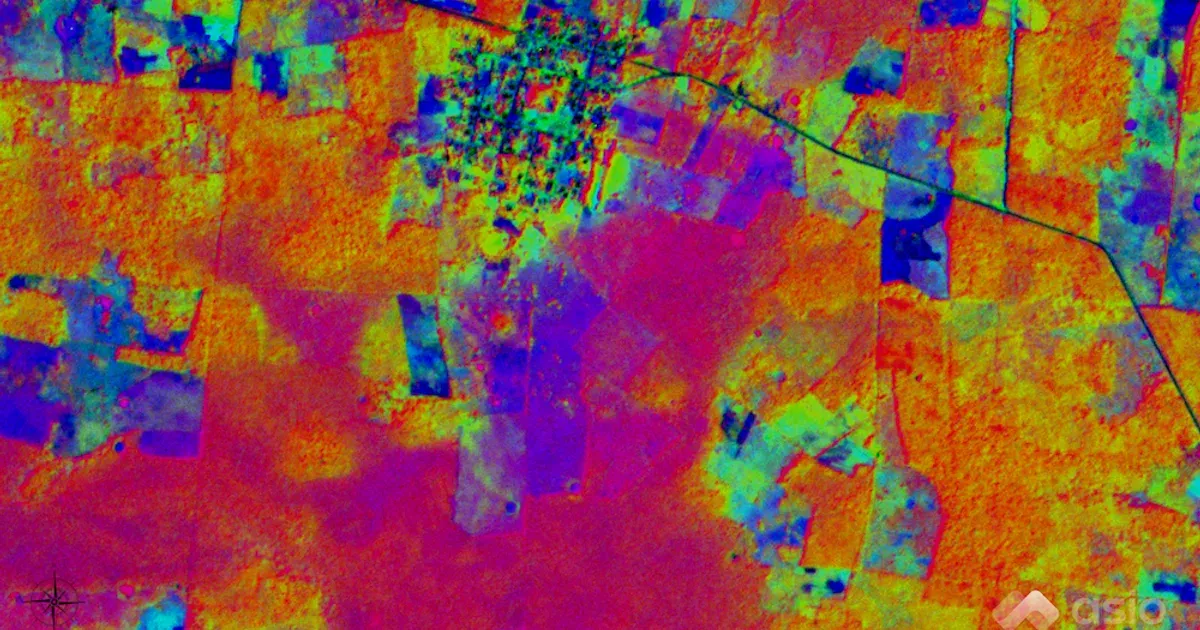 False-color composite of the first three principal components of an 8-band satellite scene, with fields in orange and magenta, a town in green and blue, and a road crossing the upper right.